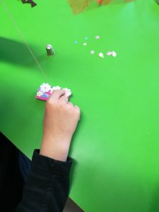 Les mains d'enfant au travail, couture de fleurs et sequins